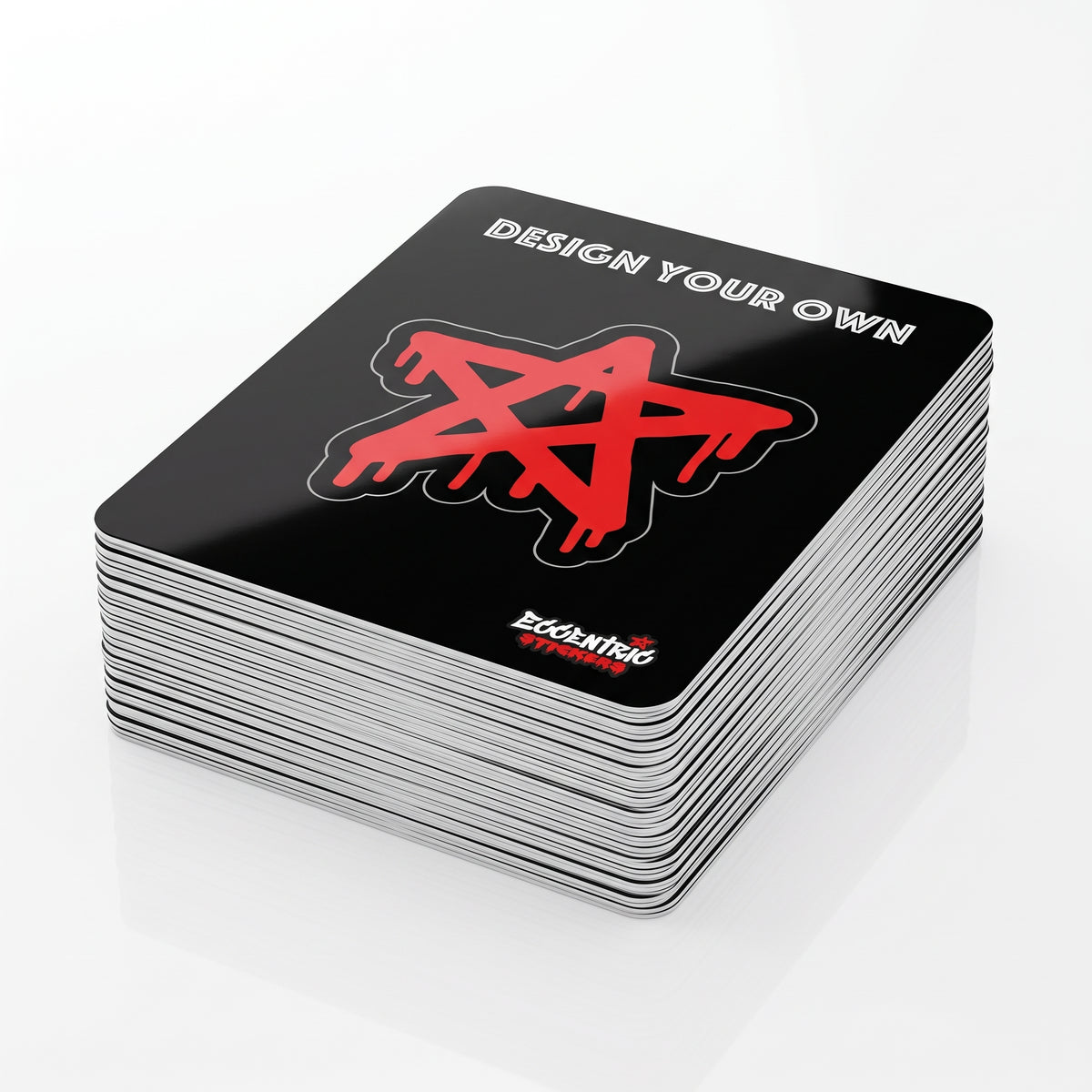 A stack of black kiss-cut sticker cards reading “design your own”, each sticker cut to shape on a whole backing card